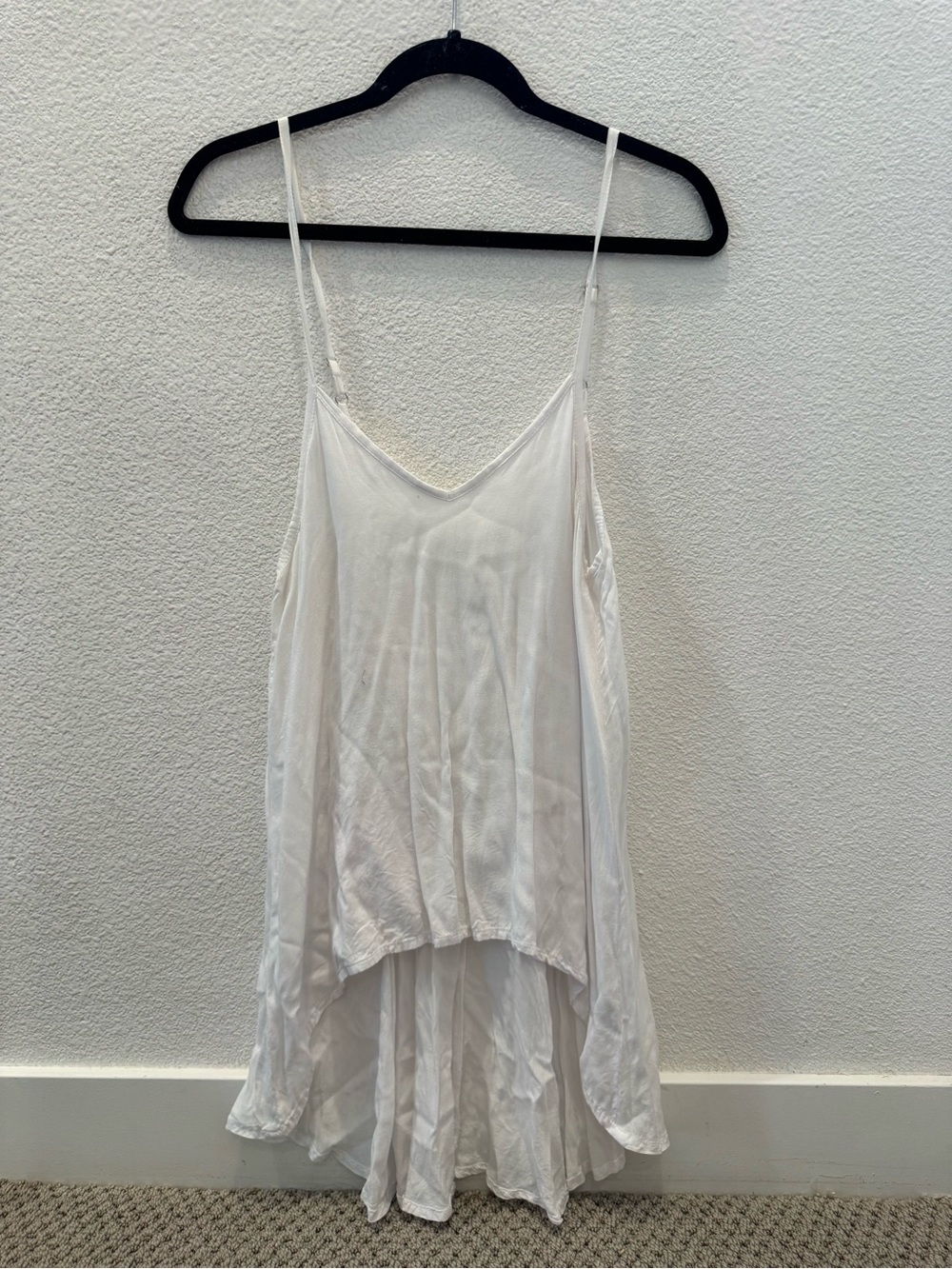 LJC Designs white tank top features a high-low hem and delicate spaghetti straps